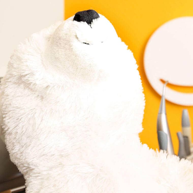 A big white plush bear in the dental chair